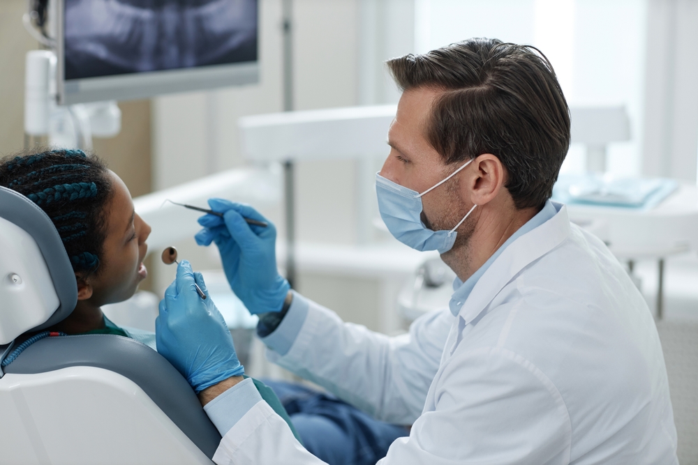 Side,View,Portrait,Of,Male,Dentist,Wearing,Mask,While,Working